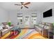 Cozy living room with a ceiling fan, leather furniture, and a colorful area rug at 412 Stone Flower Ln, Raleigh, NC 27603