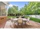 Outdoor patio area with a stone firepit, comfortable seating, and lush landscaping at 45 Mill Cir, Clayton, NC 27527
