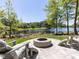 Scenic backyard featuring a cozy fire pit and comfortable Adirondack chairs overlooking the serene lake, perfect for relaxation at 4521 Briarglen Ln, Holly Springs, NC 27540