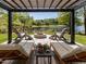 Relaxing outdoor space with comfortable seating and a fire pit beneath a pergola, offering stunning lake views at 4521 Briarglen Ln, Holly Springs, NC 27540