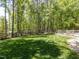 Expansive backyard featuring lush green grass and a rustic wooden fence bordering a serene wooded area at 4521 Briarglen Ln, Holly Springs, NC 27540
