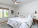 A brightly lit bedroom has a ceiling fan and window looking out onto trees at 4521 Briarglen Ln, Holly Springs, NC 27540