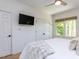 The bedroom features a ceiling fan, a view of trees, and closet with a black TV at 4521 Briarglen Ln, Holly Springs, NC 27540