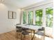 Bright dining room with large windows offering views of the wooded surroundings and stylish decor at 4521 Briarglen Ln, Holly Springs, NC 27540