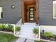 Close-up of the home's entryway featuring a welcoming front door and nicely landscaped steps at 4521 Briarglen Ln, Holly Springs, NC 27540