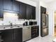The kitchen features stainless steel appliances, a double sink, granite countertops, and dark cabinetry at 4521 Briarglen Ln, Holly Springs, NC 27540