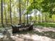 Outdoor patio area with a dining table surrounded by beautiful landscaping and wooded views at 4521 Briarglen Ln, Holly Springs, NC 27540
