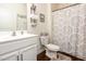 Well-lit bathroom with wood floors, white fixtures, and patterned shower curtain at 46 S Great White Way, Clayton, NC 27527