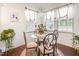 Bright breakfast nook with glass table, decorative curtains, and indoor plants, creating a cheerful space at 46 S Great White Way, Clayton, NC 27527