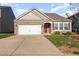 Well-maintained single-Gathering home featuring stone accents, manicured landscaping, and a welcoming front entrance at 46 S Great White Way, Clayton, NC 27527