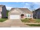 Charming home with stone accents, a two-car garage, a well-maintained yard, and a welcoming red front door at 46 S Great White Way, Clayton, NC 27527