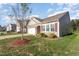 Inviting home exterior featuring stone accents, well-manicured lawn, and attached two car garage at 46 S Great White Way, Clayton, NC 27527