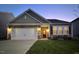 Attractive home with a two-car garage and warm exterior lighting, creating a welcoming nighttime ambiance at 46 S Great White Way, Clayton, NC 27527
