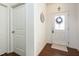 Welcoming foyer with hardwood floors, white walls, and a front door with glass accents, next to a coat closet at 46 S Great White Way, Clayton, NC 27527