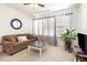Comfortable living room with a brown sofa, round mirror, and large windows at 46 S Great White Way, Clayton, NC 27527