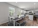 Open dining area with wood floors, modern decor, and a window next to the kitchen at 473 Lavatera Dr, Wendell, NC 27591
