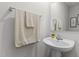Half bathroom featuring a pedestal sink, mirror, and decorative elements at 473 Lavatera Dr, Wendell, NC 27591