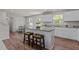Open kitchen boasts an island with seating, stainless steel appliances, white cabinets, and adjacent dining area at 473 Lavatera Dr, Wendell, NC 27591