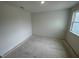 A bright, unfinished bedroom with a window and prepped for flooring installation at 503 Eastwood St, Durham, NC 27703