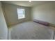 Bright bedroom with a window overlooking the side yard and flooring ready for installation at 503 Eastwood St, Durham, NC 27703