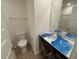 Bathroom with a dark vanity, modern lighting, and a toilet in front of a large mirror at 505 Eastwood St, Durham, NC 27704