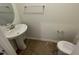 Compact powder room featuring a pedestal sink, oval mirror, toilet, and chrome hardware at 505 Eastwood St, Durham, NC 27704