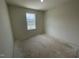 Bright bedroom with a large window offering natural light and a view of the outdoors at 505 Eastwood St, Durham, NC 27704