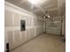 Spacious unfinished garage with drywall, an electrical panel, and a garage door opener at 505 Eastwood St, Durham, NC 27704