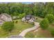 Aerial view shows a two-story home with curved driveway, mature trees, and swimming pool at 5209 Thistleby Rd, Fuquay Varina, NC 27526