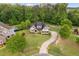 Aerial view of a two-story home with a large lawn, curved driveway and mature trees at 5209 Thistleby Rd, Fuquay Varina, NC 27526