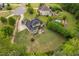 Aerial view displays the back of the house with patio, large lawn, trees and swimming pool at 5209 Thistleby Rd, Fuquay Varina, NC 27526