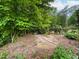 A lush backyard with a brick-lined path, dense trees, and established greenery at 5209 Thistleby Rd, Fuquay Varina, NC 27526