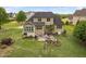 An aerial view showcasing the backyard patio, grilling area, landscaped features and spacious lawn at 5209 Thistleby Rd, Fuquay Varina, NC 27526