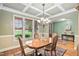 Formal dining room with hardwood floors, chandelier, and natural light from the large windows at 5209 Thistleby Rd, Fuquay Varina, NC 27526