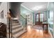 Inviting foyer with hardwood floors, staircase, and a view into the dining room at 5209 Thistleby Rd, Fuquay Varina, NC 27526
