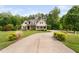 Attractive home featuring a long driveway surrounded by lush greenery and landscaping at 5209 Thistleby Rd, Fuquay Varina, NC 27526