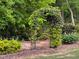 Beautiful garden path featuring a trellised archway and manicured greenery at 5209 Thistleby Rd, Fuquay Varina, NC 27526