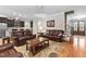 Spacious living room with hardwood floors, leather furniture, and an open floor plan to the kitchen at 5209 Thistleby Rd, Fuquay Varina, NC 27526