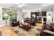 An open living room with a connected kitchen area, leather furniture, and natural lighting at 5209 Thistleby Rd, Fuquay Varina, NC 27526