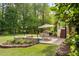 Outdoor patio with a stone fire pit and dining set at 5209 Thistleby Rd, Fuquay Varina, NC 27526