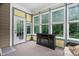 Bright sunroom with multiple windows, an electric fireplace, and a view of the yard at 5209 Thistleby Rd, Fuquay Varina, NC 27526