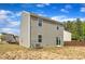 Back exterior of home, with vinyl siding, with grass and trees in the distance at 536 Gusty Ln, Zebulon, NC 27597