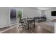 Corner dining area with a black table, grey chairs and view into living room with grey sectional and backyard at 536 Gusty Ln, Zebulon, NC 27597