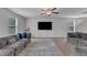 Open living room featuring two large grey sofas, flat screen television and several windows for natural light at 536 Gusty Ln, Zebulon, NC 27597