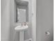 Elegant powder room with a pedestal sink, a decorative mirror, and neutral paint at 536 Gusty Ln, Zebulon, NC 27597