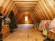 Unfinished attic space featuring exposed wooden beams, flooring and a lone window at 602 Shelley Rd, Raleigh, NC 27609