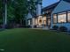 A backyard with an open covered patio with seating and fireplace, and manicured lawn at 602 Shelley Rd, Raleigh, NC 27609