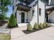 A beautiful black front door framed by white brick, gray trim, and a well-manicured walkway at 602 Shelley Rd, Raleigh, NC 27609