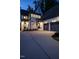 A charming front entrance at dusk with white brick, gray trim, and lush landscaping leading to a black front door at 602 Shelley Rd, Raleigh, NC 27609