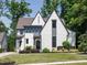 A charming two-story home with white brick, gray trim, a manicured lawn, and lush landscaping around the foundation at 602 Shelley Rd, Raleigh, NC 27609